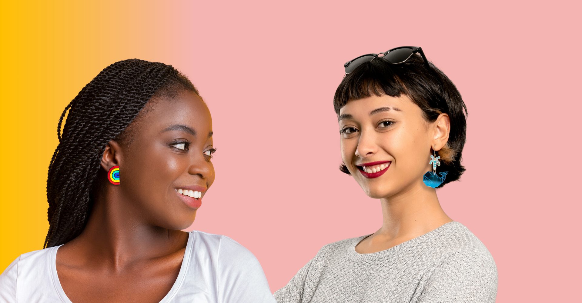 Picture of two women looking at each other, one is wearing rainbow studs and the other is wearing dangly whale earrings.